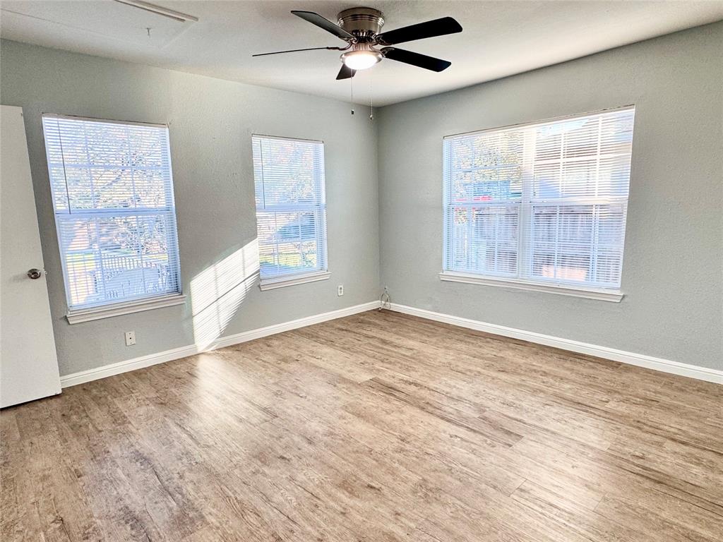 202 North Riverside Drive Fort Worth, TX 76111 - Photo 15 of 25 a view of an empty room with a window and wooden floor