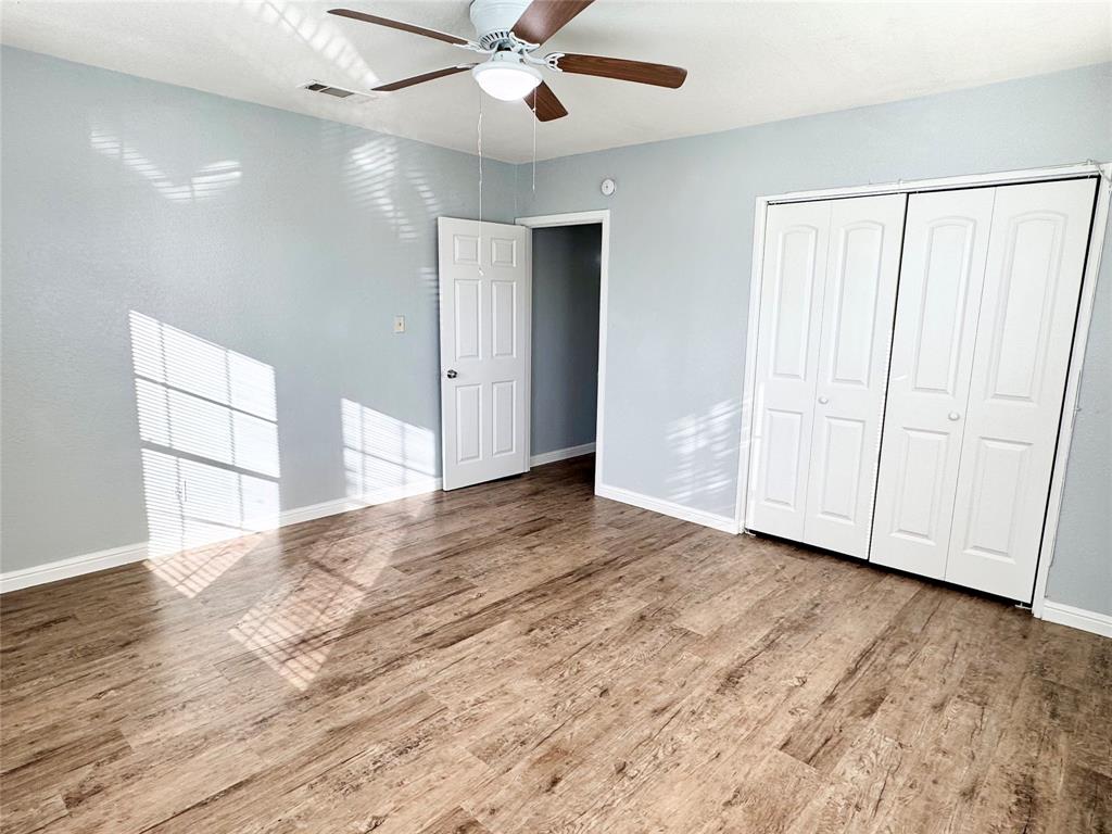 202 North Riverside Drive Fort Worth, TX 76111 - Photo 19 of 25 an empty room with wooden floor fan and windows