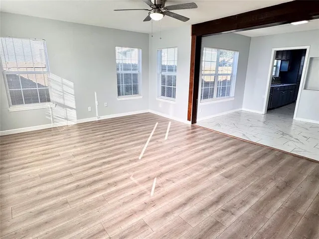 a view of a livingroom with wooden floor and a ceiling fan