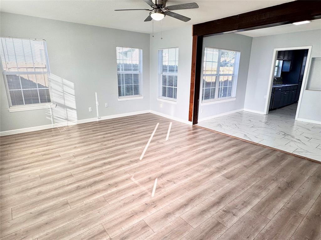 202 North Riverside Drive Fort Worth, TX 76111 - Photo 2 of 25 a view of a livingroom with wooden floor and a ceiling fan