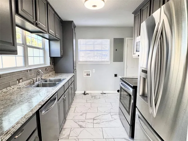 a bathroom with a granite countertop sink a toilet a mirror and a tub