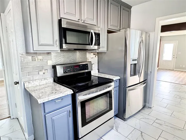 a kitchen with stainless steel appliances granite countertop a stove microwave and refrigerator