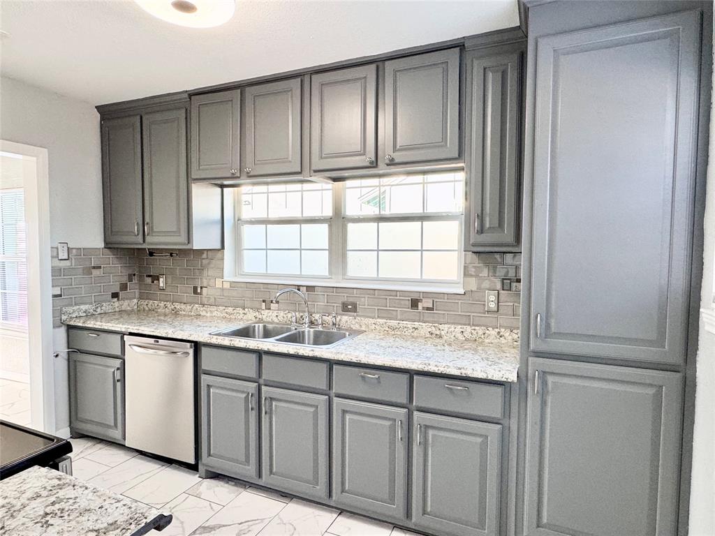 202 North Riverside Drive Fort Worth, TX 76111 - Photo 9 of 25 a kitchen with granite countertop cabinets sink and window