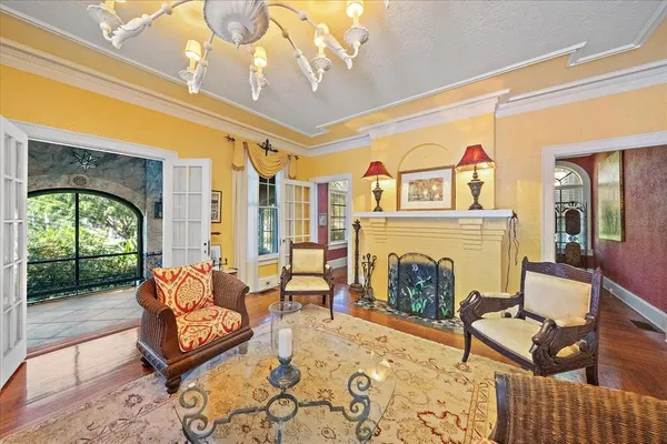 a living room with furniture a chandelier and a dining table