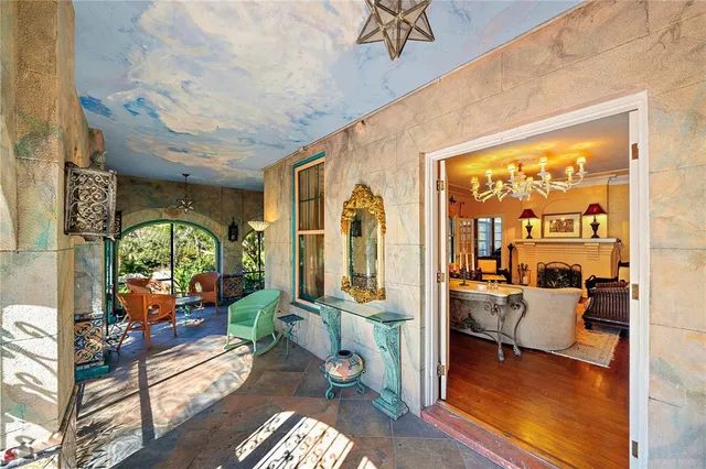 a view of a brick house with many windows plants and large tree