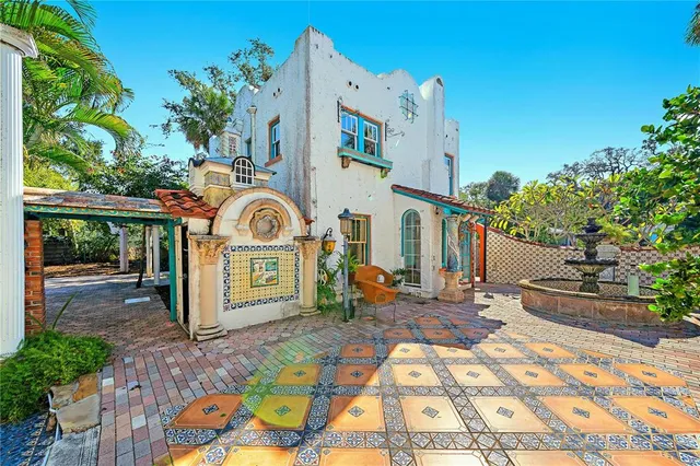 a view of a house with a yard and a fountain
