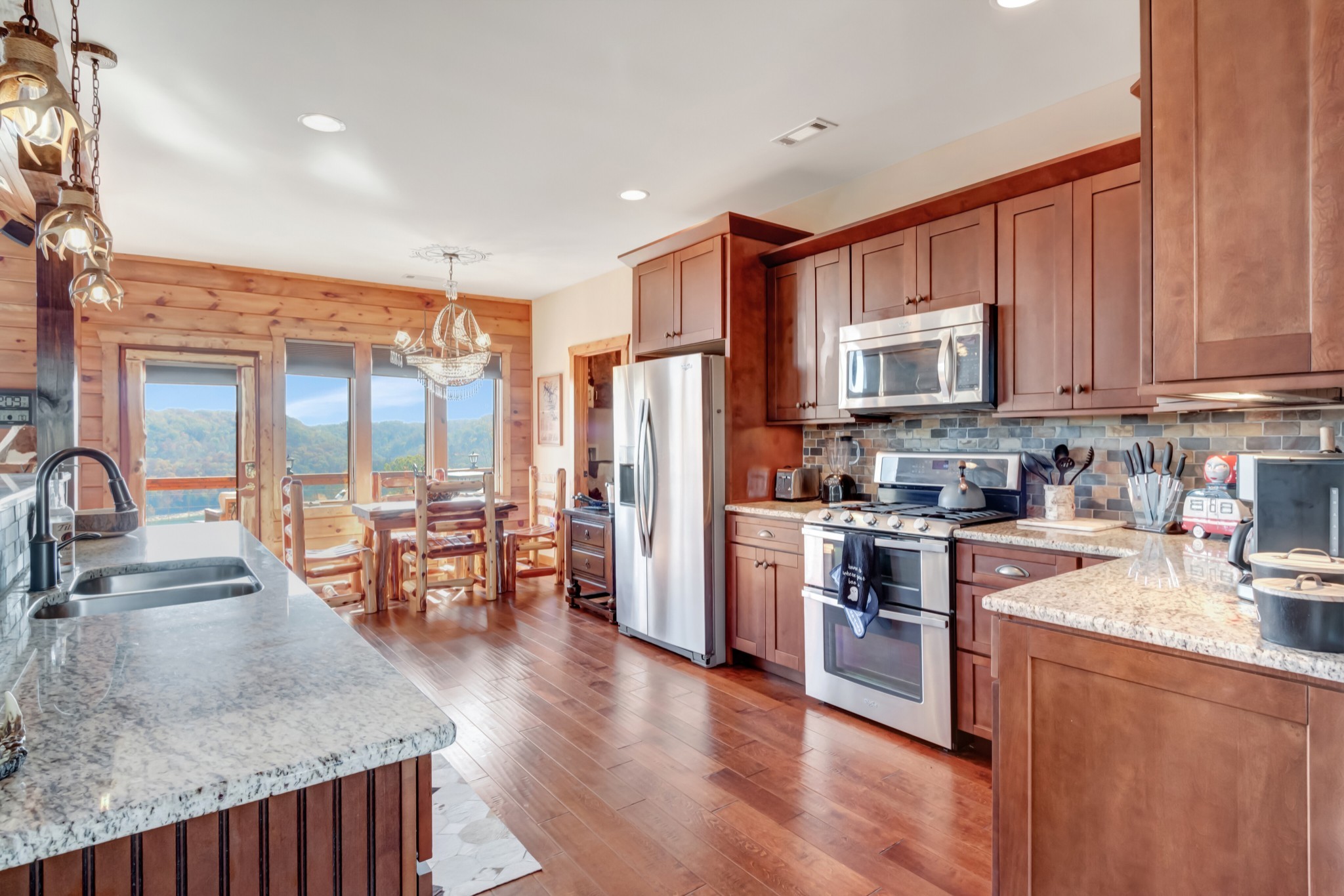 5320 Coconut Ridge Road Smithville, TN 37166 - Photo 25 of 52 a kitchen with stainless steel appliances granite countertop a stove top oven a sink a dining table and chairs with wooden floor
