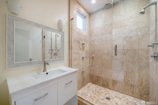 a spacious bathroom with a shower sink and mirror