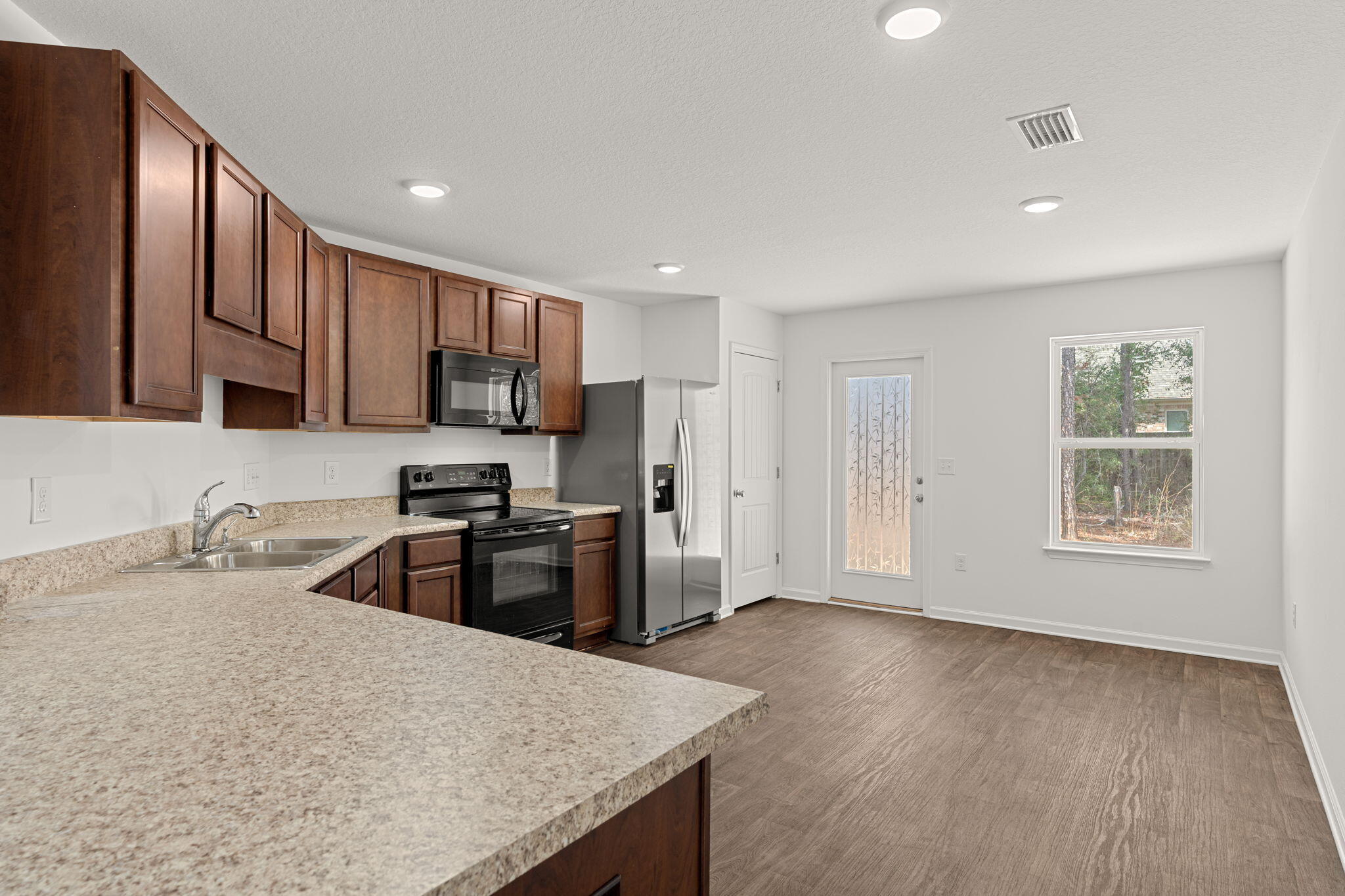 545 Earl Godwin Road Freeport, FL 32439 - Photo 11 of 50 a kitchen with granite countertop a refrigerator stove top oven and sink
