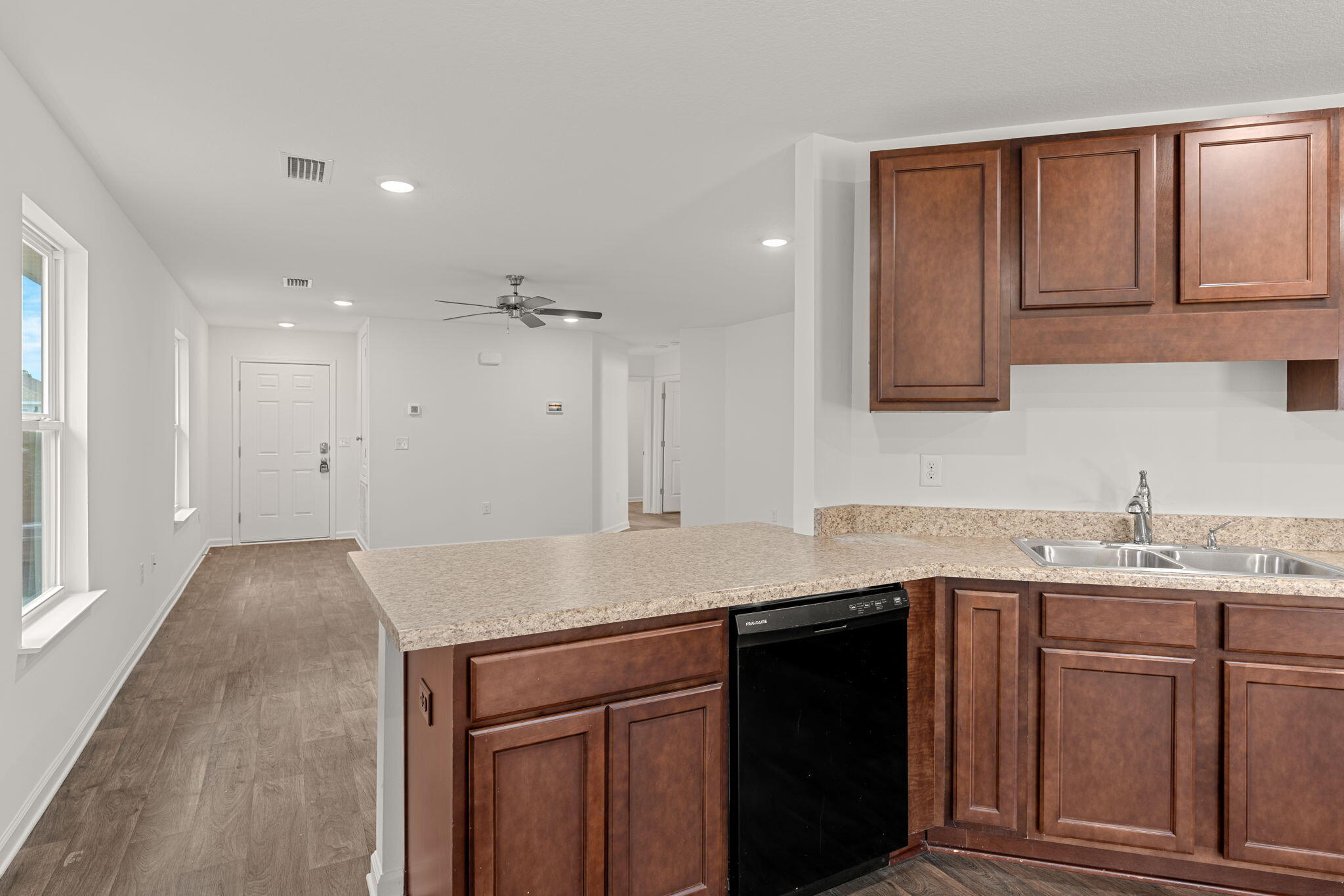 545 Earl Godwin Road Freeport, FL 32439 - Photo 14 of 50 a kitchen with a sink dishwasher and white cabinets with wooden floor