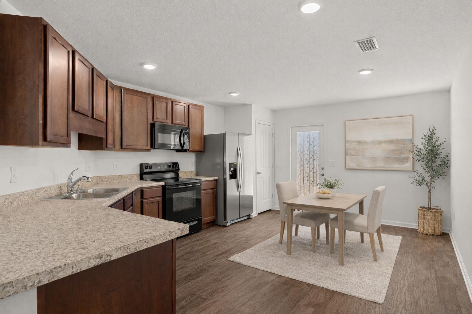545 Earl Godwin Road Freeport, FL 32439 - Photo 10 of 50 a kitchen with granite countertop kitchen island wooden cabinets and stainless steel appliances