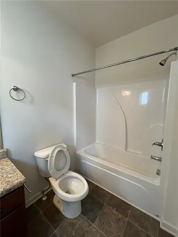 a white toilet and tub sitting next to a bathroom sink