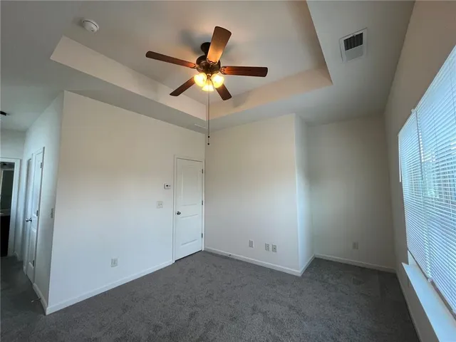 an empty room with windows and fan