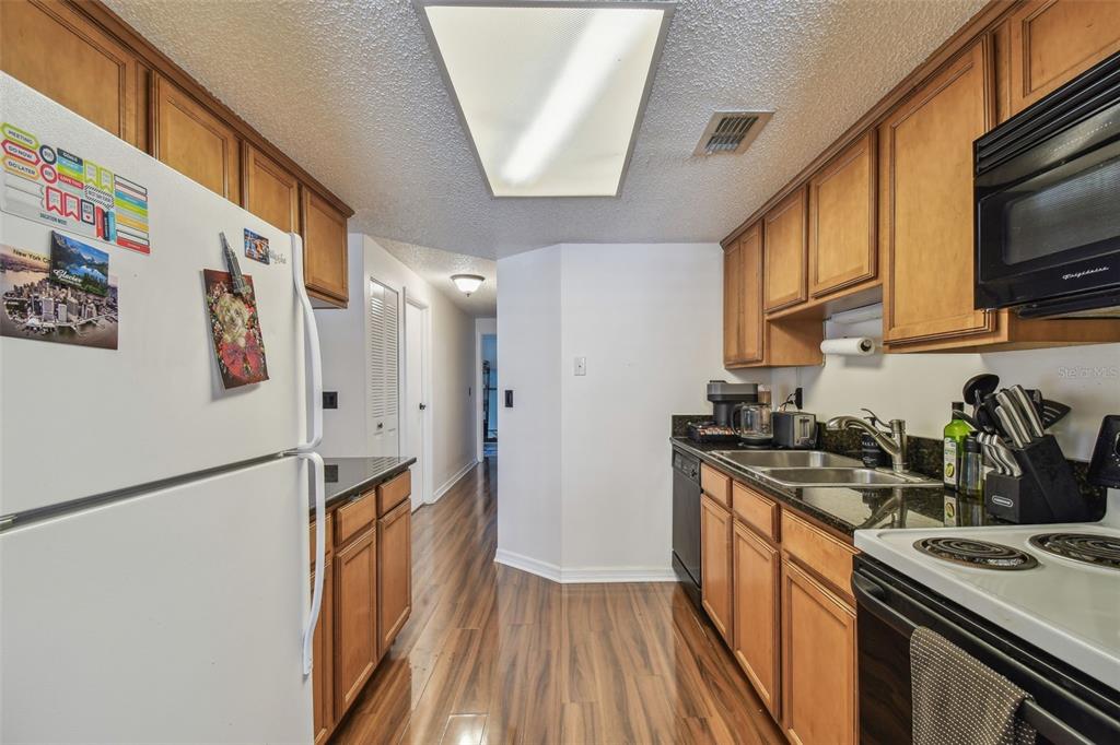 134 Sycamore Lane, Unit H Oldsmar, FL 34677 - Photo 13 of 44 a kitchen with stainless steel appliances granite countertop a stove a sink and a refrigerator