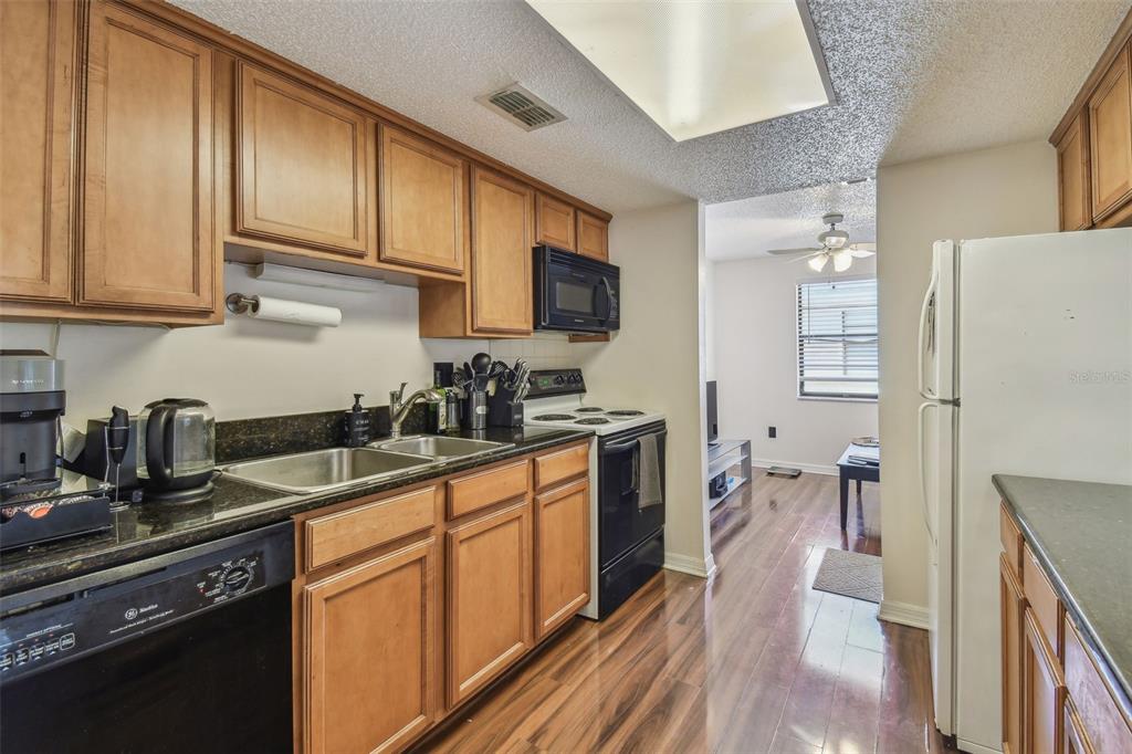 134 Sycamore Lane, Unit H Oldsmar, FL 34677 - Photo 14 of 44 a kitchen with stainless steel appliances granite countertop a refrigerator a sink dishwasher a stove top oven a counter space and cabinets