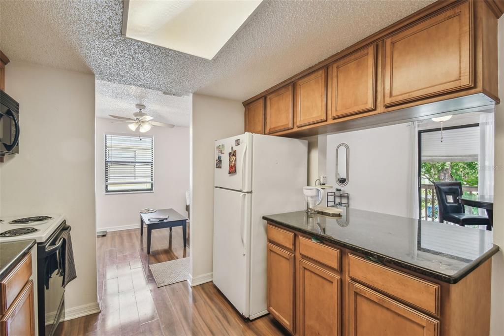 134 Sycamore Lane, Unit H Oldsmar, FL 34677 - Photo 15 of 44 a kitchen with stainless steel appliances granite countertop a refrigerator a sink dishwasher and white cabinets with wooden floor