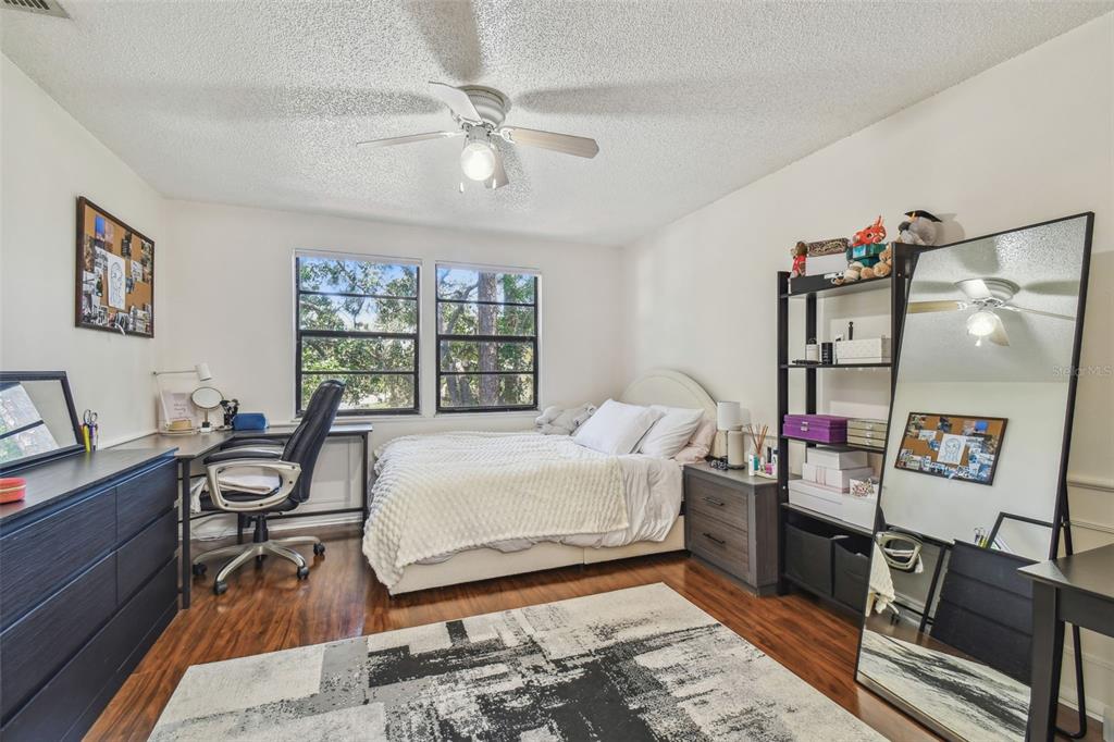 134 Sycamore Lane, Unit H Oldsmar, FL 34677 - Photo 16 of 44 a bedroom with a bed and wooden floor