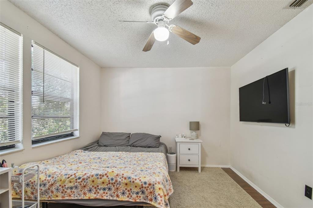 134 Sycamore Lane, Unit H Oldsmar, FL 34677 - Photo 28 of 44 a bedroom with a large bed and a flat tv screen on dresser