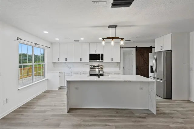 a view of kitchen with center island and stainless steel appliances