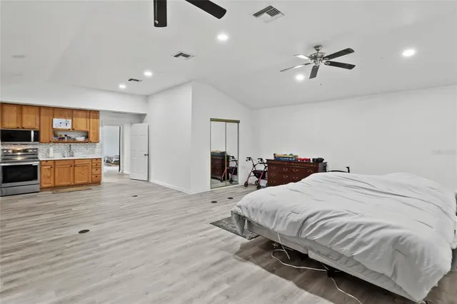 a spacious bedroom with a bed and a flat screen tv