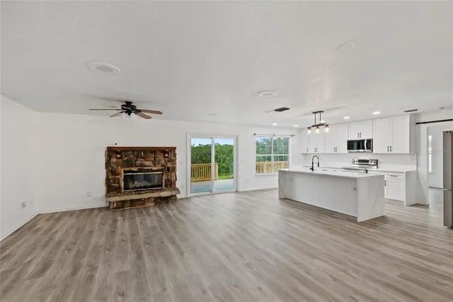 a large white kitchen with wooden floors and a fireplace