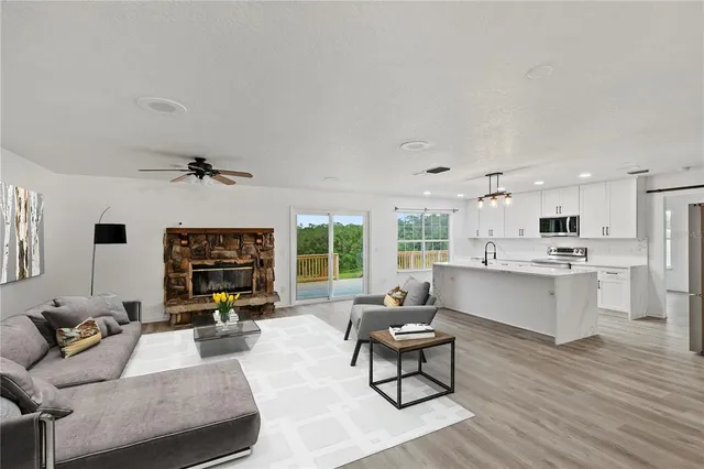 a living room with furniture flat screen tv and window
