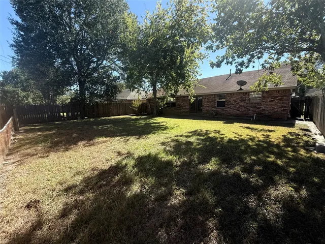 a yard with a house in the background