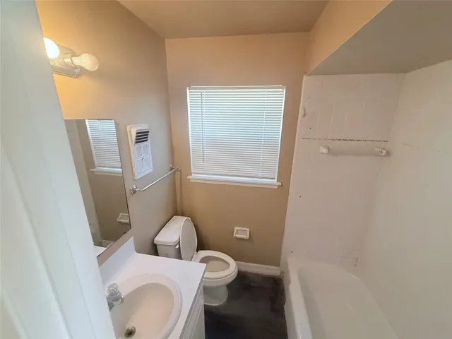 a white toilet sitting next to a bathroom sink