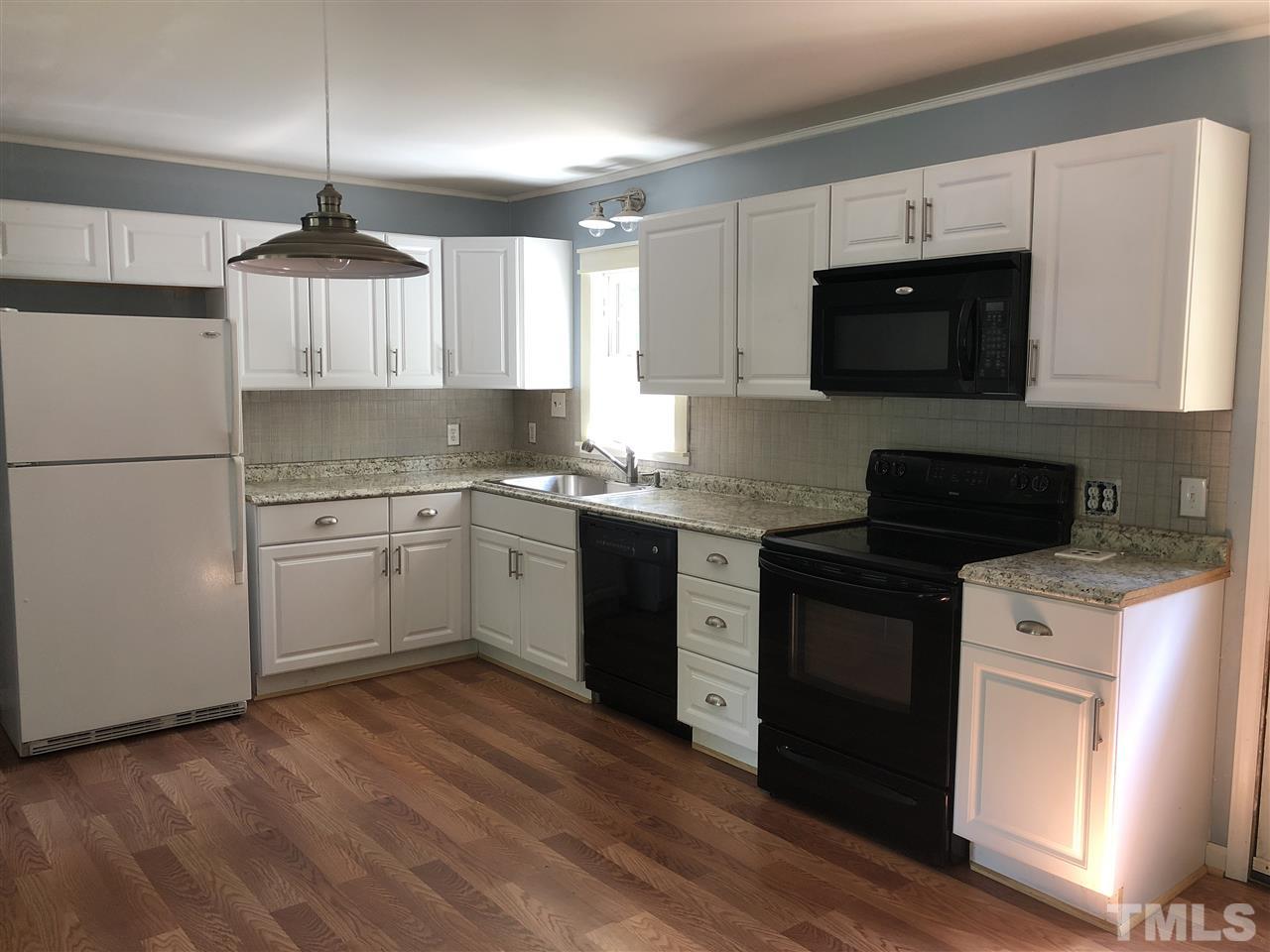 303 Lancaster Road Mebane, NC 27302 - Photo 4 of 9 a kitchen with stainless steel appliances granite countertop a sink a stove a refrigerator and cabinets
