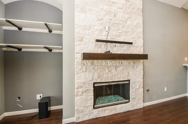 a view of a livingroom with wooden floor and a fireplace