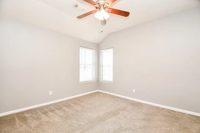 an empty room with a window and a ceiling fan