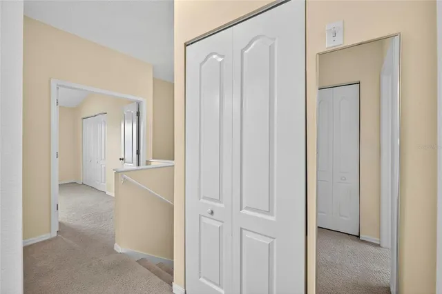 an empty room with a chandelier fan and windows