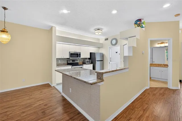 a kitchen with stainless steel appliances granite countertop a refrigerator and a stove top oven