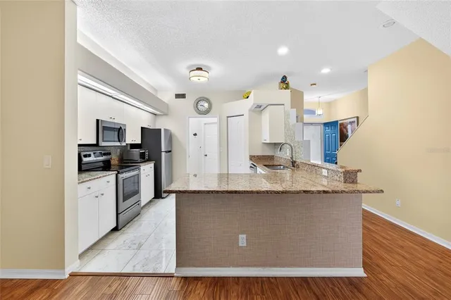 a large kitchen with stainless steel appliances granite countertop a large counter top and a stove