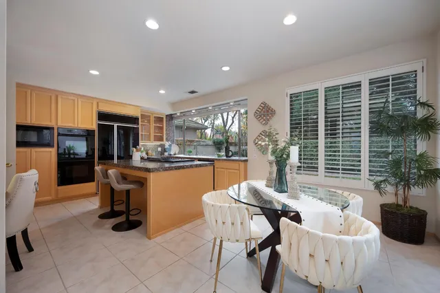 a dining room with furniture and a large window