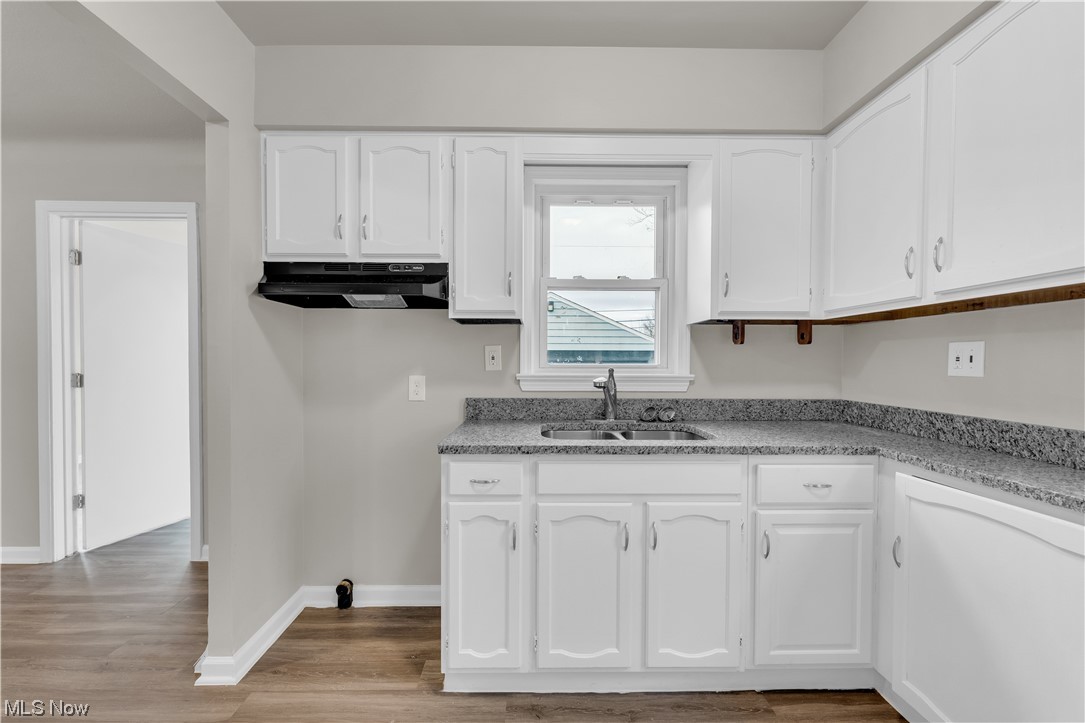 16301 Turney Road Maple Heights, OH 44137 - Photo 23 of 35 Kitchen with white cabinets, sink, and light hardwood / wood-style floors