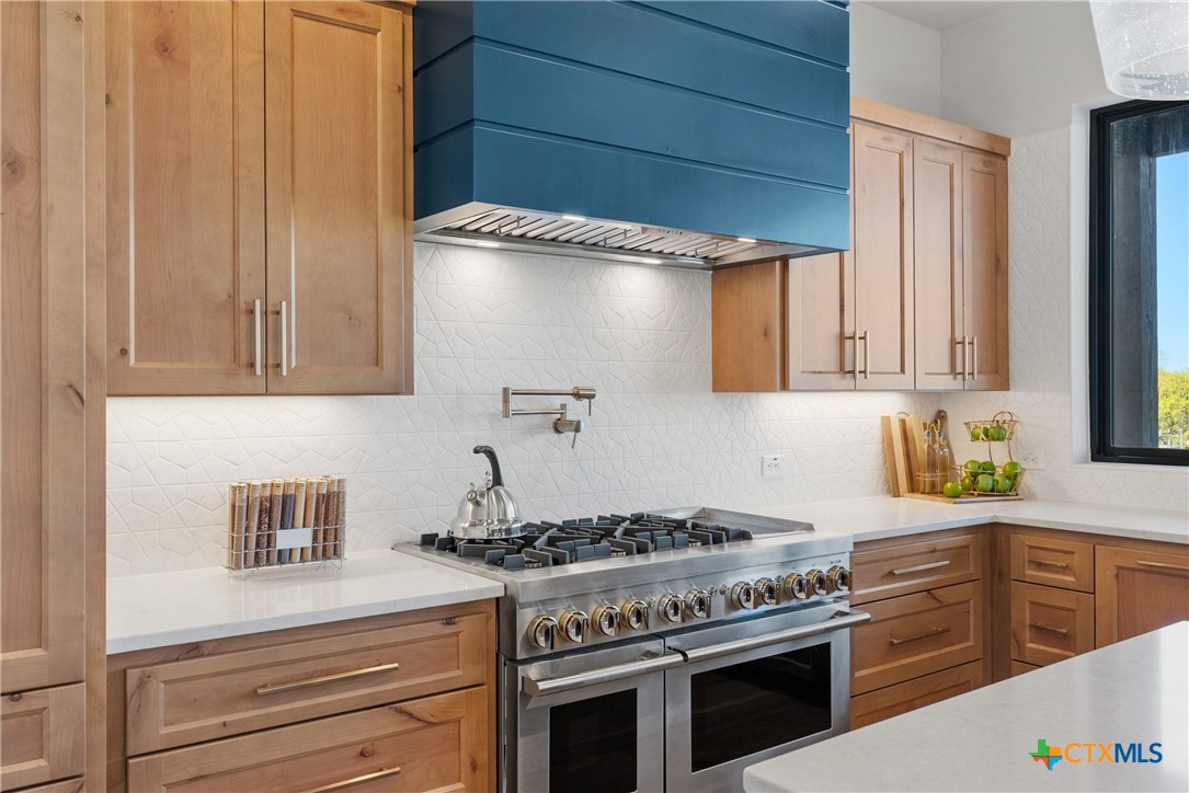 175 Pointview Drive Marble Falls, TX 78654 - Photo 20 of 34 a kitchen with granite countertop a stove and a sink