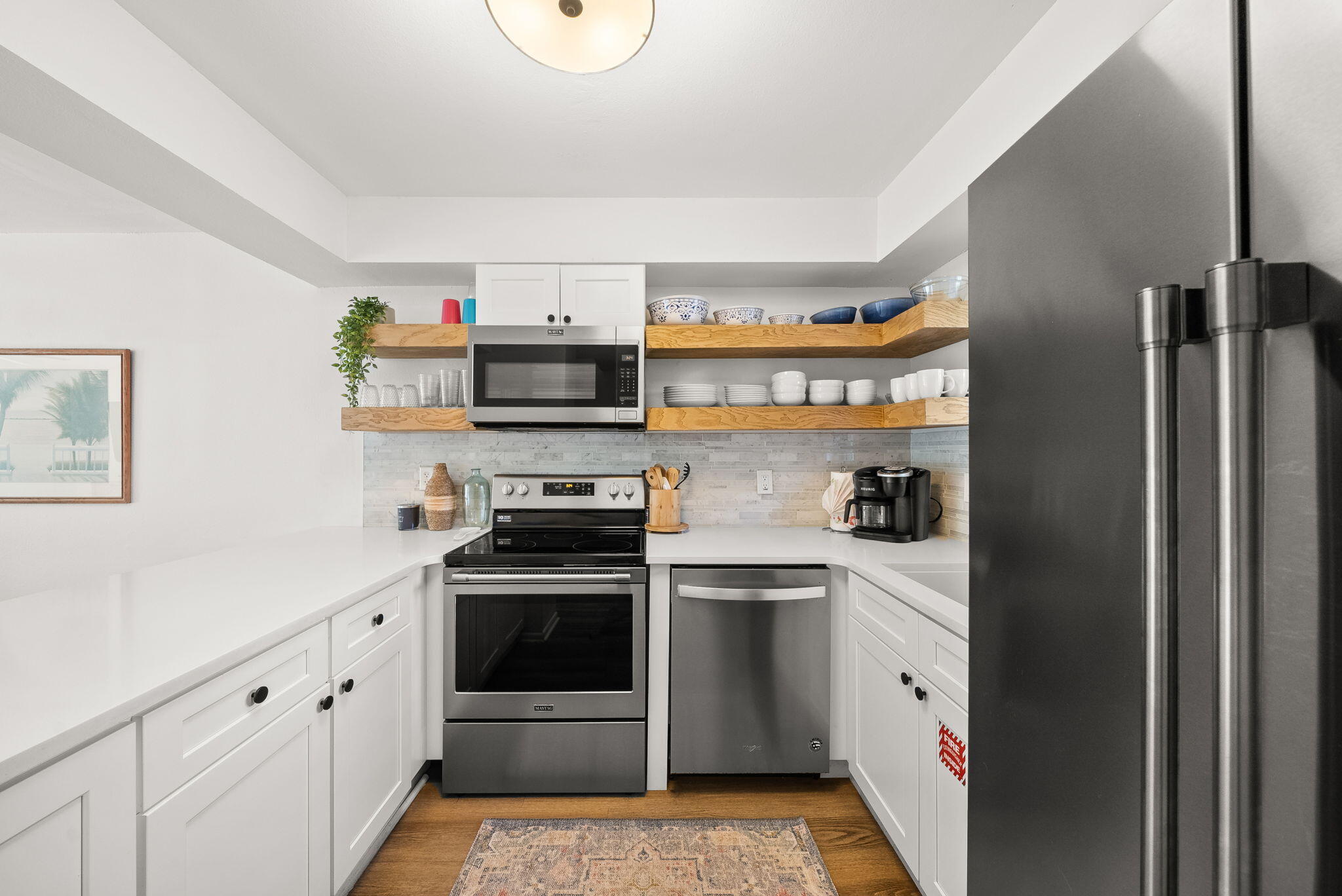 17620 Front Beach Road, Unit J2 Panama City Beach, FL 32413 - Photo 2 of 30 a kitchen with stainless steel appliances a stove a sink and a refrigerator