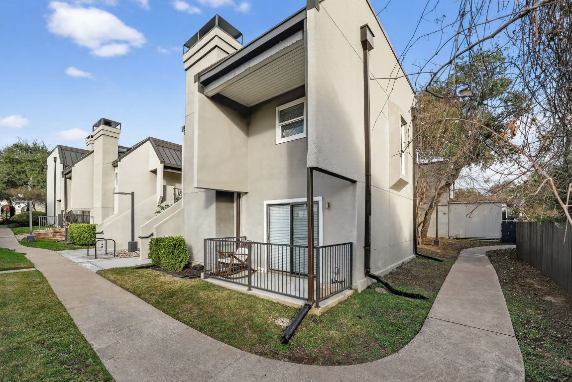 935 La Posada Drive, Unit 128 Austin, TX 78752 - Photo 1 of 18 a view of a white house with a small yard and sitting area