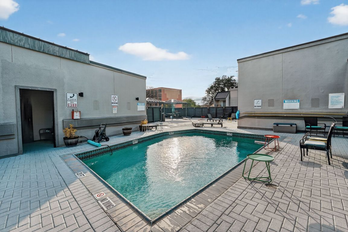 935 La Posada Drive, Unit 128 Austin, TX 78752 - Photo 16 of 18 a swimming pool with outdoor seating and yard