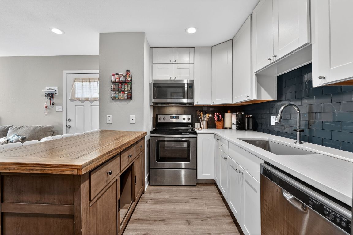 935 La Posada Drive, Unit 128 Austin, TX 78752 - Photo 3 of 18 a kitchen with a sink stove and cabinets