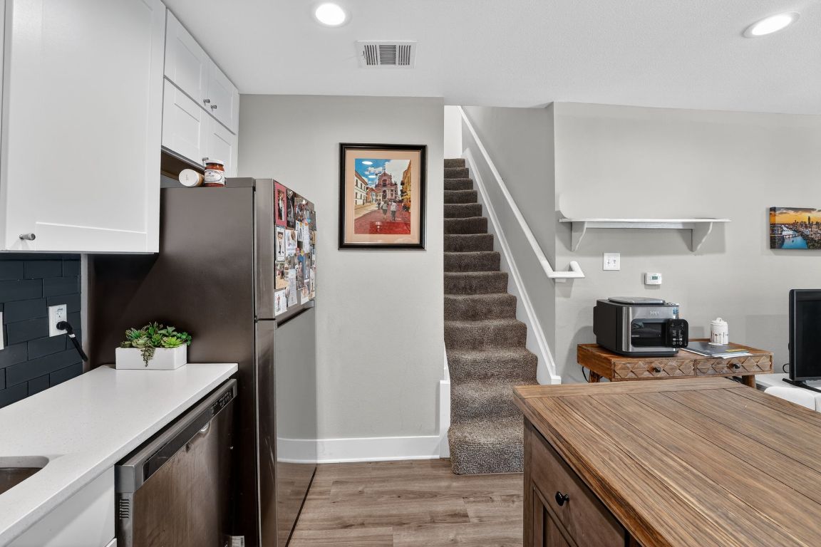 935 La Posada Drive, Unit 128 Austin, TX 78752 - Photo 4 of 18 a kitchen with stainless steel appliances a refrigerator sink and microwave