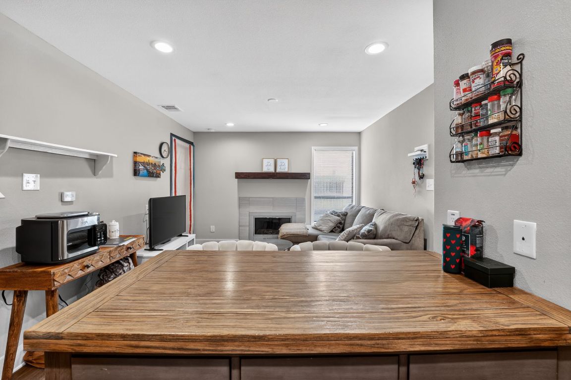 935 La Posada Drive, Unit 128 Austin, TX 78752 - Photo 6 of 18 a room with kitchen island a flat screen tv and a couch