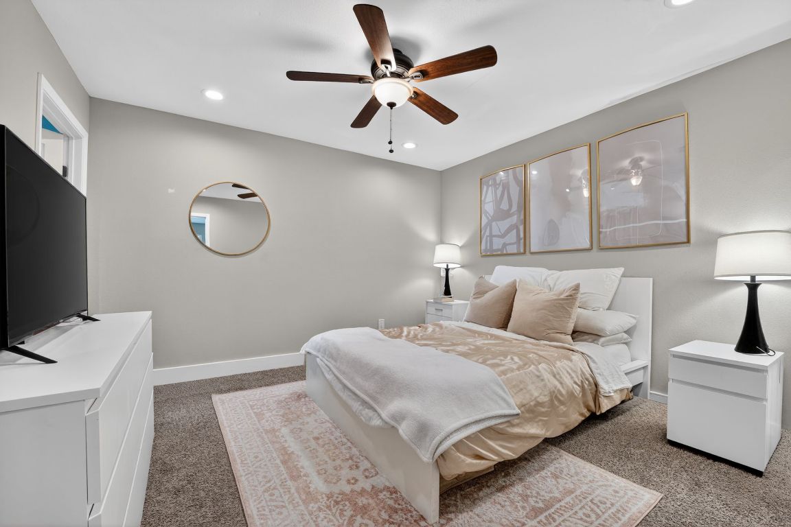 935 La Posada Drive, Unit 128 Austin, TX 78752 - Photo 10 of 18 a bedroom with a large bed and a flat screen tv