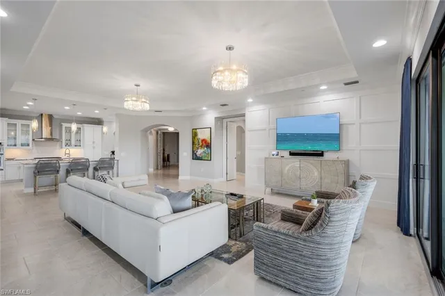 a living room with furniture kitchen view and a wooden floor
