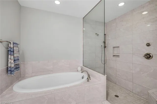 a bathroom with a double vanity sink a mirror and a bathtub