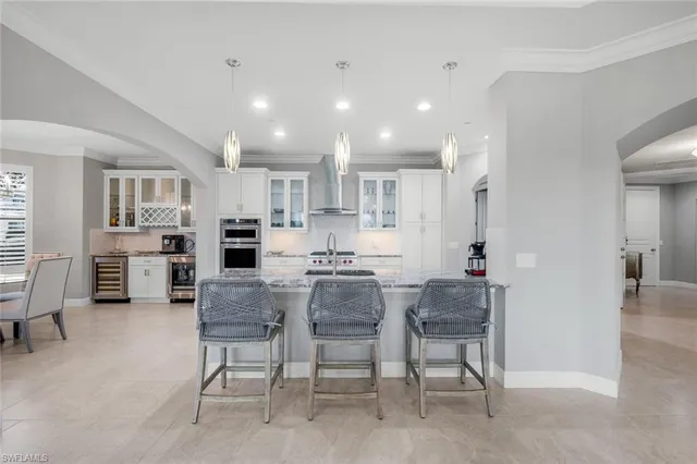 a view of kitchen with stainless steel appliances refrigerator stove dining table and chairs