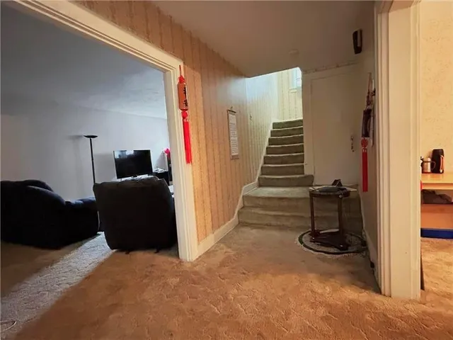a view of hallway with couch and a closet