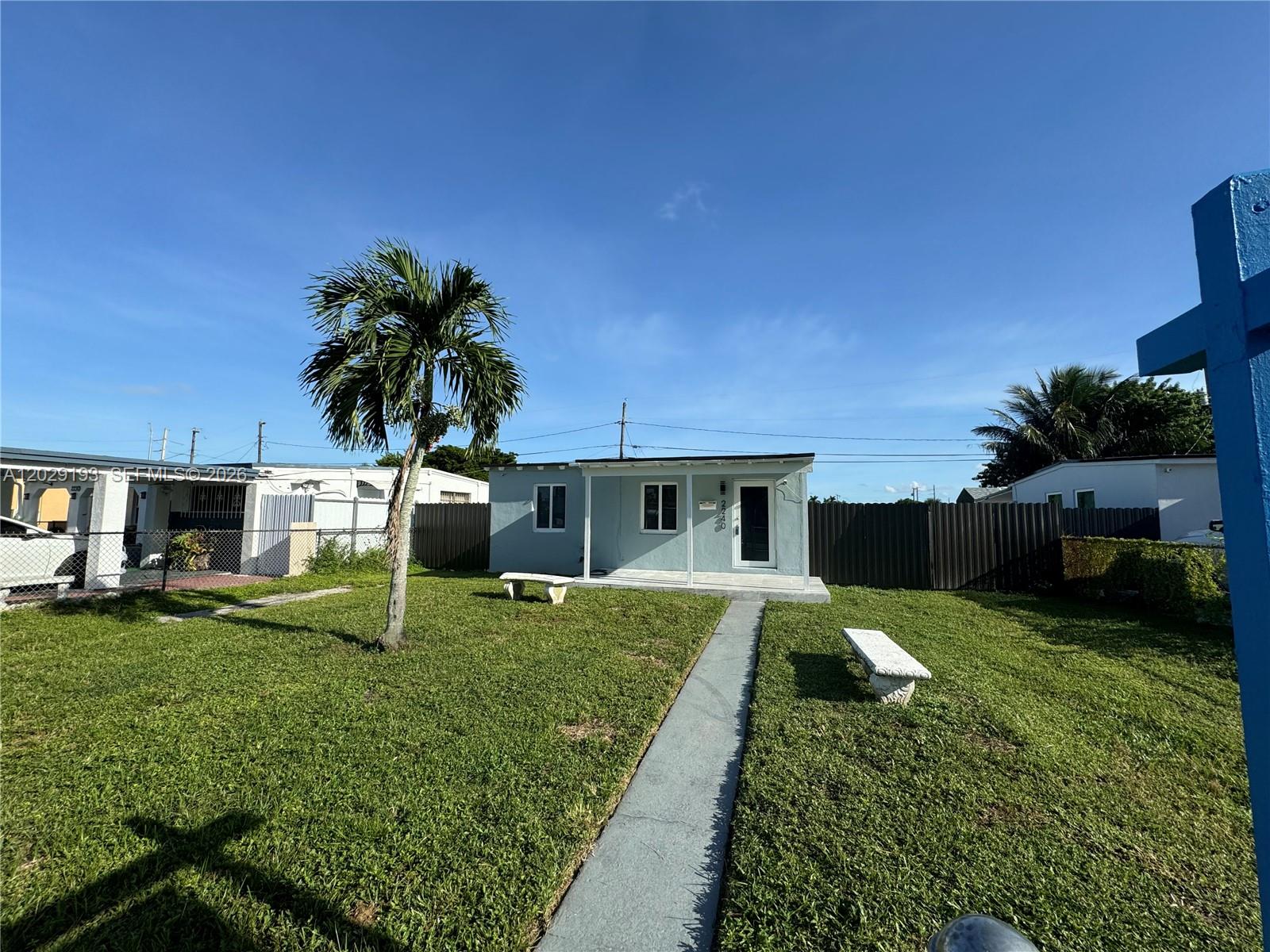 2240 Rutland Street Opa-Locka, FL 33054 - Photo 10 of 11 a front view of a house with a yard and garage