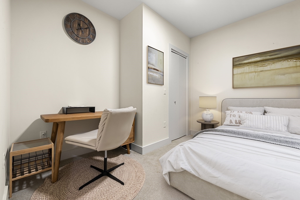 121-127 Portland Street, Unit 307 Boston, MA 02114 - Photo 11 of 27 a bedroom with a bed a chair and a wall painting